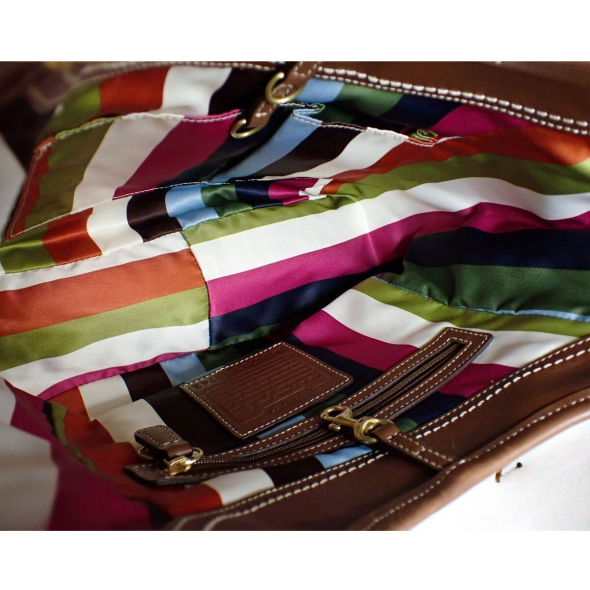 Coach – Bolso de hombro de piel marrón coñac con bolsillo frontal y forro multicolor